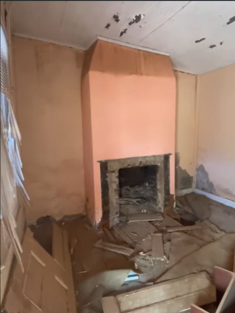 A screenshot from the real estate video shows debris in front of the fireplace in the living room.