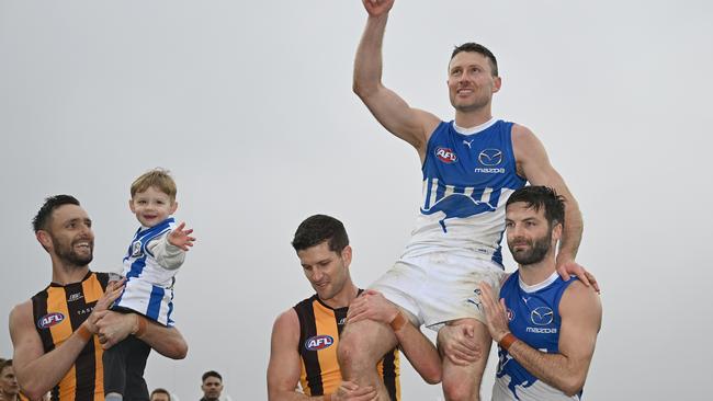 Liam Shiels is chaired from the field by Luke Breust of the Hawks and Luke McDonald of the Kangaroos after his final AFL match. (Photo by Steve Bell/AFL Photos/via Getty Images)