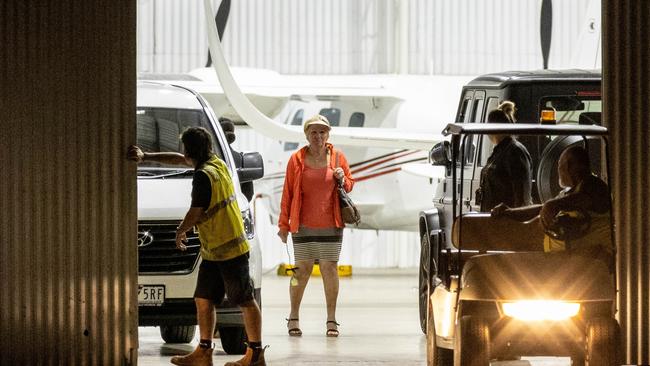 A woman believed to be Warne’s mother holds a white rose inside the hanger. Picture: Jake Nowakowski