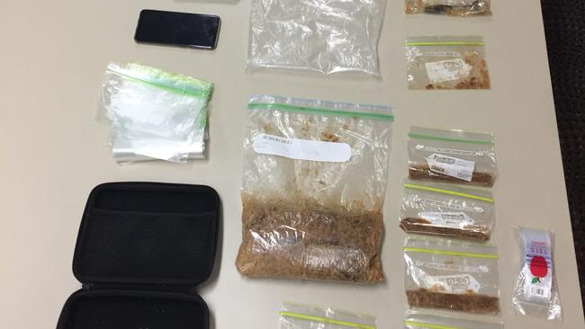 Drugs and items uncovered during a police search in Airlie Beach on Thursday. Police allege more than 1kg of MDMA was uncovered.