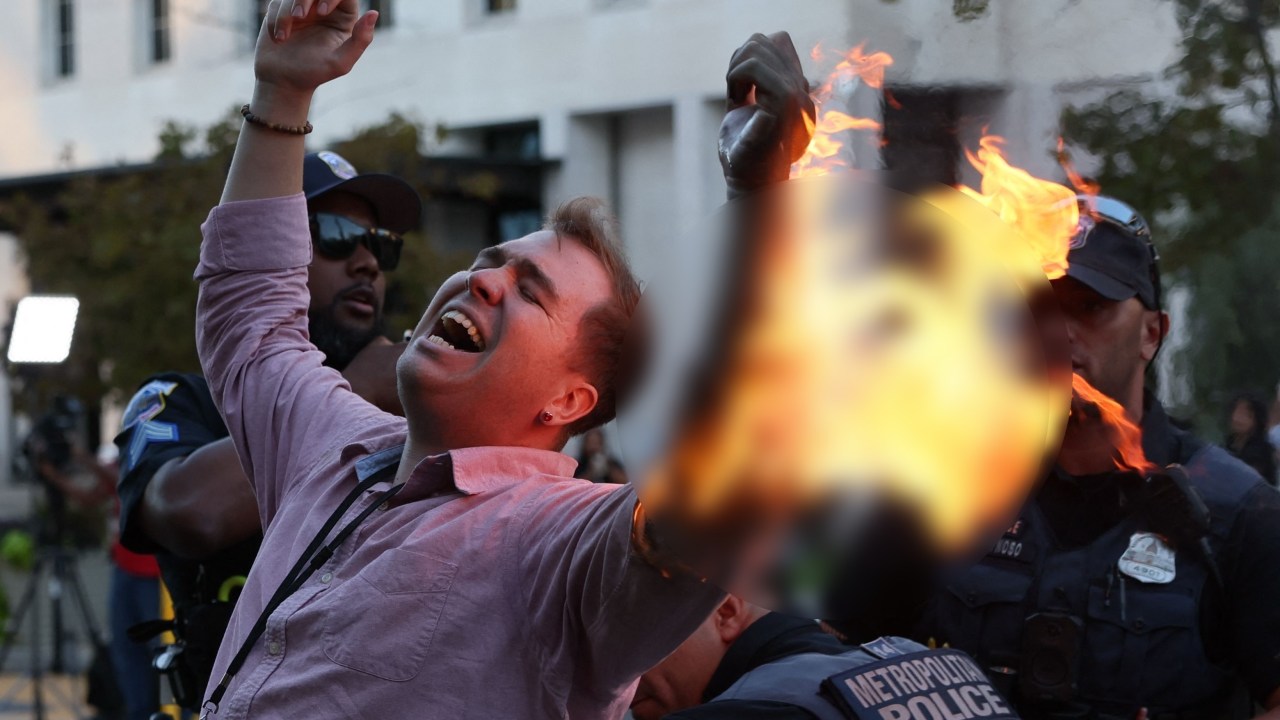 A man tries to set himself on fire as people demonstrate to mark one year of the war between Hamas and Israel in front of the White House in Washington, DC, on October 5, 2024. (Photo by Ting Shen / AFP)