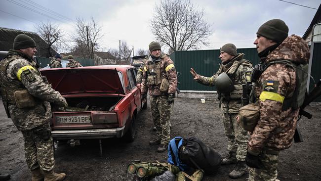 Ukrainian soldiers unload weapons, northeast of Kyiv. Picture: AFP