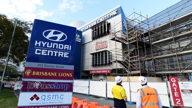 Workers look on outside the Gabba after scaffolding went up. Picture: NCA NewsWire / Albert Perez