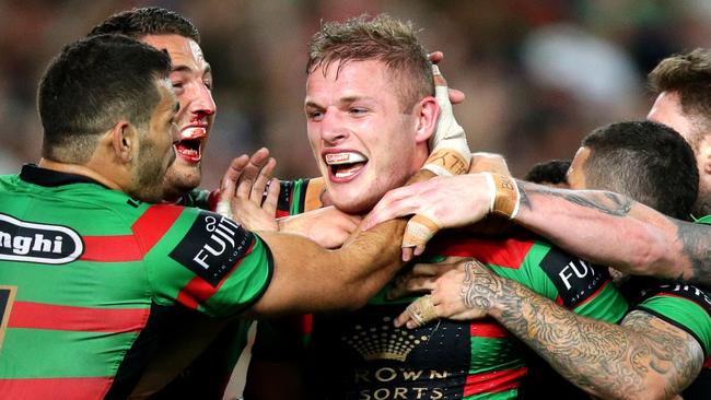 South Sydney's George Burgess busts the tackle and scores a try.