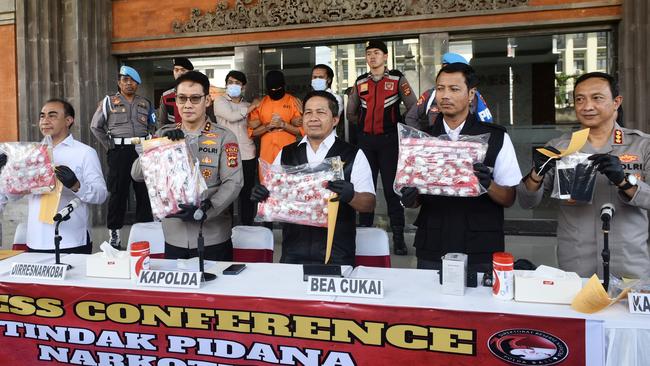 Lamar Ahchee pictured in orange, being escorted by Bali police during a press conference. Picture: Lukman S. Bintoro