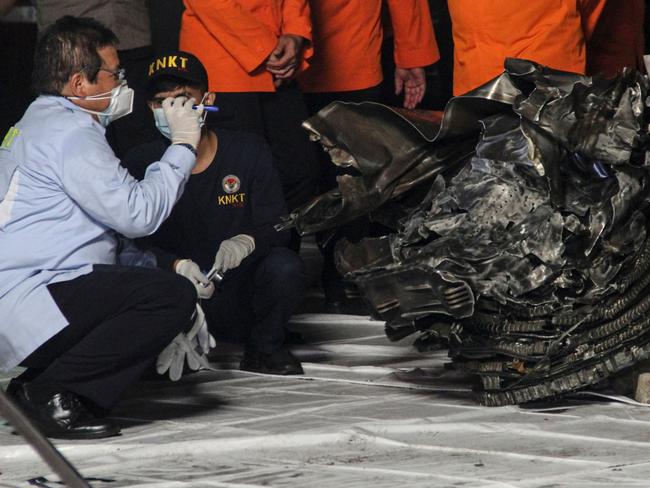 An official of the National Transportation Safety Committee (KNKT) inspects one of the engines recovered from the crash site of Sriwijaya Air flight SJ182. Picture: AFP