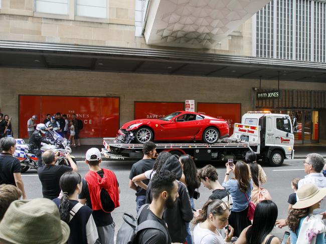 Pedestrians and shoppers gather to watch the Ferrari being loaded onto a tow truck. Picture: Tim Pascoe