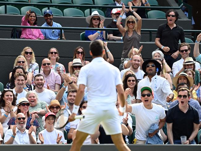 Fans cheer as Serbia's Novak Djokovic celebrates a point against US player Denis Kudla during their men's singles third round match on the fifth day of the 2021 Wimbledon Championships at The All England Tennis Club in Wimbledon, southwest London, on July 2, 2021. (Photo by Glyn KIRK / AFP) / RESTRICTED TO EDITORIAL USE