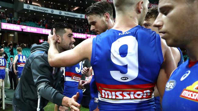 Marcus Adams is consoled by teammates after injuring his foot during the Western Bulldogs’ loss to Sydney. Picture: Getty Images