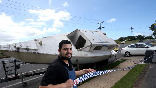 Owner of Punjabi Nights at Freshwater Deepak Kumar in front of the yacht that has been dumped on the side of Kamerunga Rd. PICTURE: ANNA ROGERS