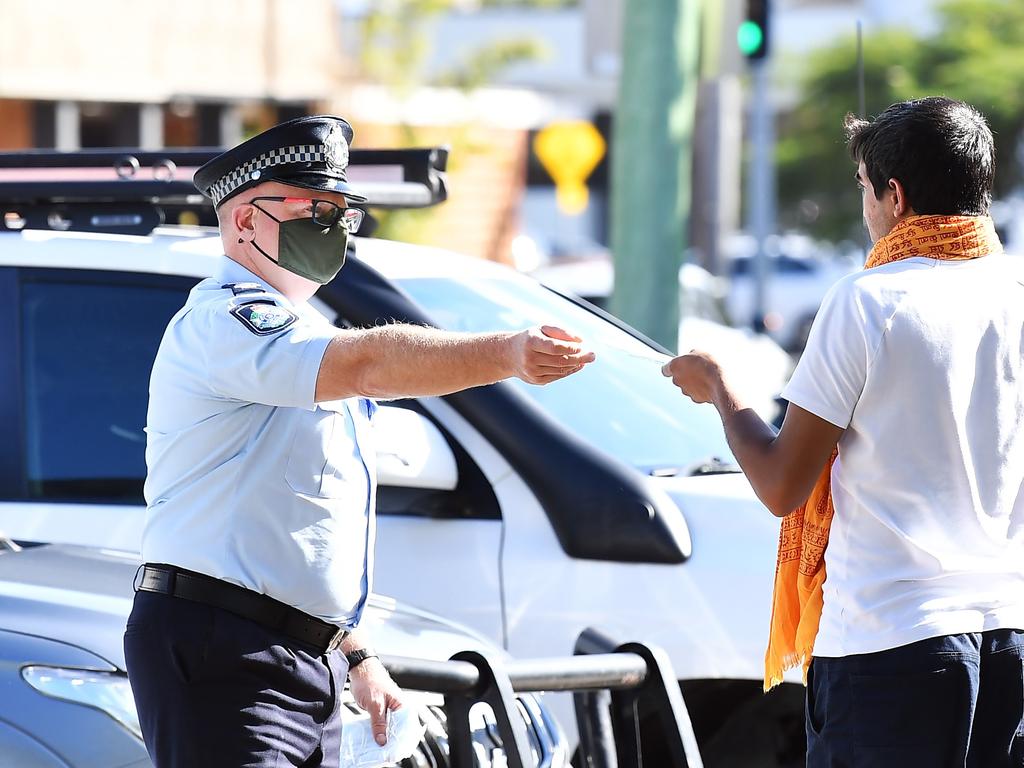 Police hand out free masks to the public at Cotton Tree on the Sunshine Coast. Picture: Patrick Woods.