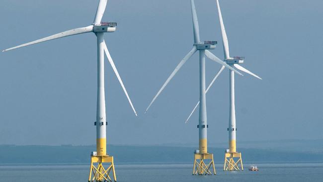 (FILES) A ferry navigates past wind turbines off the coast of Aberdeen in the North East of Scotland, on April 29, 2022. In Europe's oil and gas "capital" of Aberdeen, voters are apprehensive about Labour's plans for combatting climate change if the opposition party wins next month's UK general election as expected. Labour scaled back its green investment pledges under pressure from the ruling Conservatives about how it would fund them, but still promises to make Britain a "clean energy superpower". (Photo by Andy Buchanan / AFP)