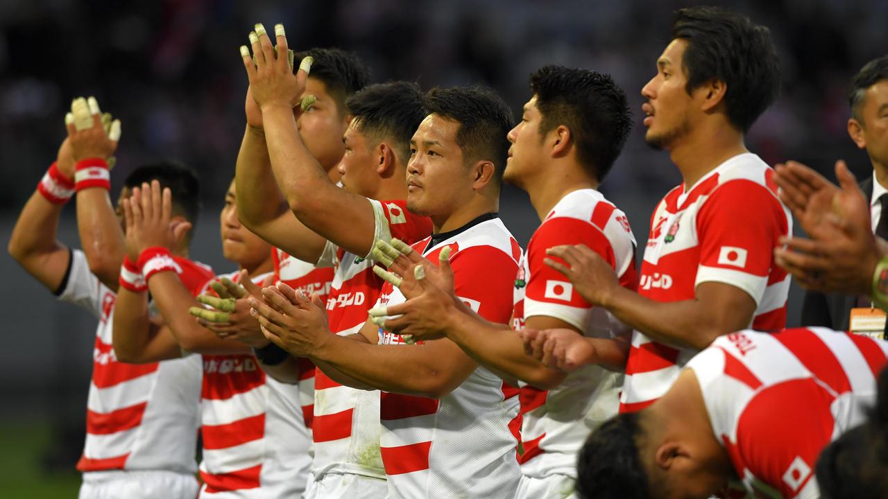 Japanese players applaud fans after a match against the All Blacks.