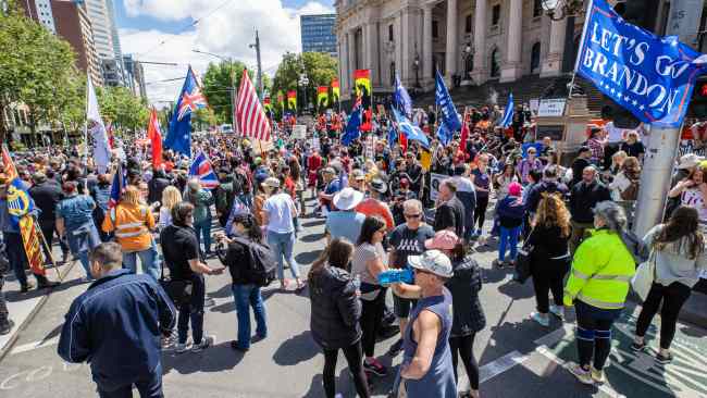 Demonstrators can be seen carrying Australia, American and Eureka flags. Picture: Jason Edwards