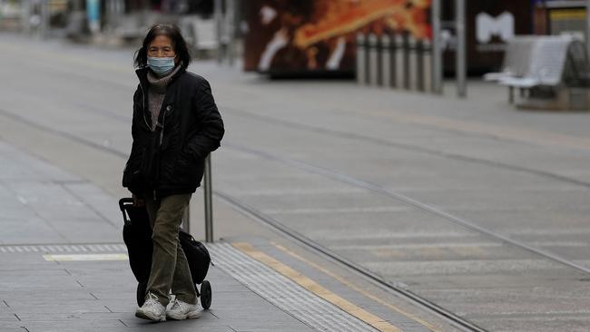 A pedestrian walks through the quiet streets of Melbourne on Saturday, the ninth day of the city’s latest lockdown. Picture: AFP