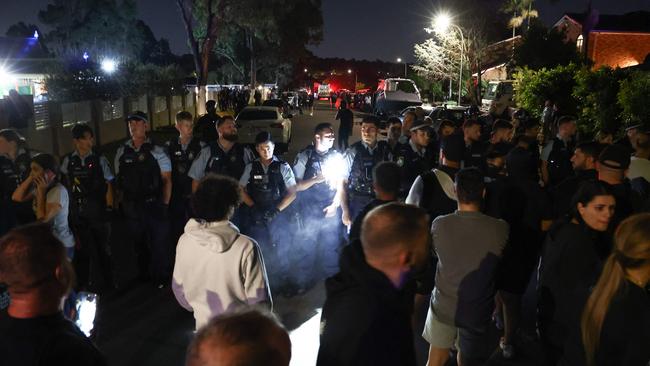 Locals gather with police guarding the perimeter of the Christ the Good Shepherd Church in Sydney's western suburb of Wakeley.