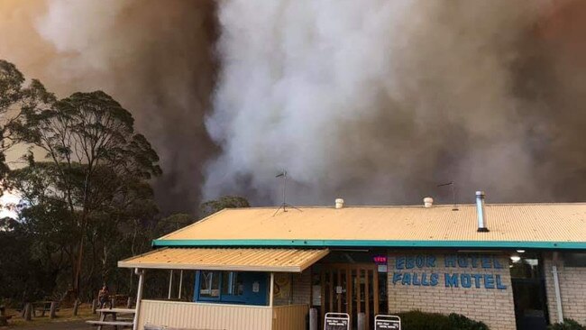 Bush burns behind the Ebor Falls Hotel Motel on Friday.