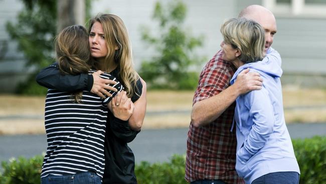 Friends of Richard Russell console each other yesterday at the Orting Valley Police and Fire Department. Picture: AP