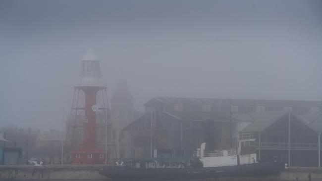 Most parts of Adelaide were shrouded in heavy fog for much of the morning. The lighthouse and tugboat at Port Adelaide. Picture: Dean Martin