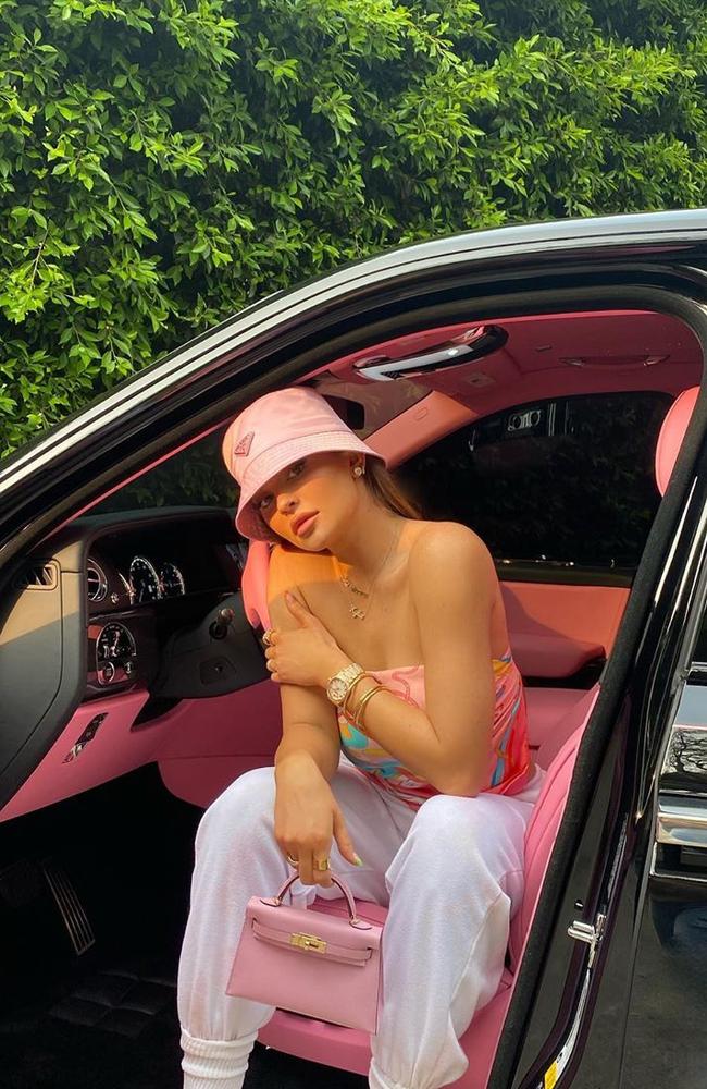 Kylie Jenner posing in one of her several luxury cars.