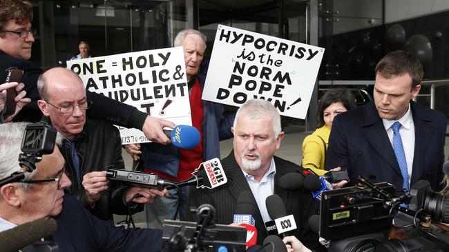 Protesters flanked victims’ advocate Peter Gogarty as he spoke outside the Newcastle Local Court on Tuesday. AAP Image/Darren Pateman