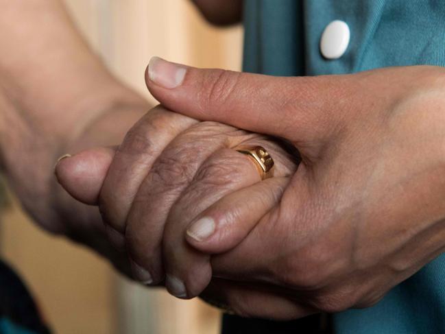 This picture taken on June 25, 2019 in Clermont-Ferrand shows a personal care assistant holding the hand of an elderly person as she visits her house to help her to avoid heatstroke and dehydration during the heatwave. - Forecasters say Europeans will feel sizzling heat this week with temperatures soaring as high as 40 degrees Celsius (104 degrees Fahrenheit) in an "unprecedented" June heatwave hitting much of Western Europe. (Photo by Thierry Zoccolan / AFP)