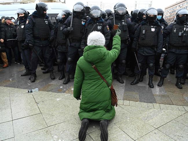 A woman kneels in front of a group of riot police during a rally in support of jailed opposition leader Alexei Navalny in downtown Moscow. Picture: AFP