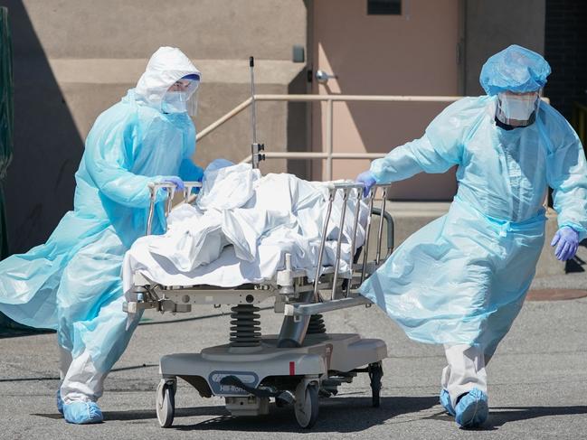 (FILES) In this file photo taken on April 6, 2020, bodies are moved to a refrigeration truck serving as a temporary morgue at Wyckoff Hospital in the Borough of Brooklyn in New York. (Photo by Bryan R. Smith / AFP)