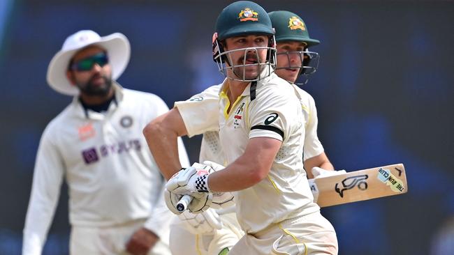 Australia's Travis Head (C) and Marnus Labuschagne (R) run between the wickets. (Photo by Punit PARANJPE / AFP)