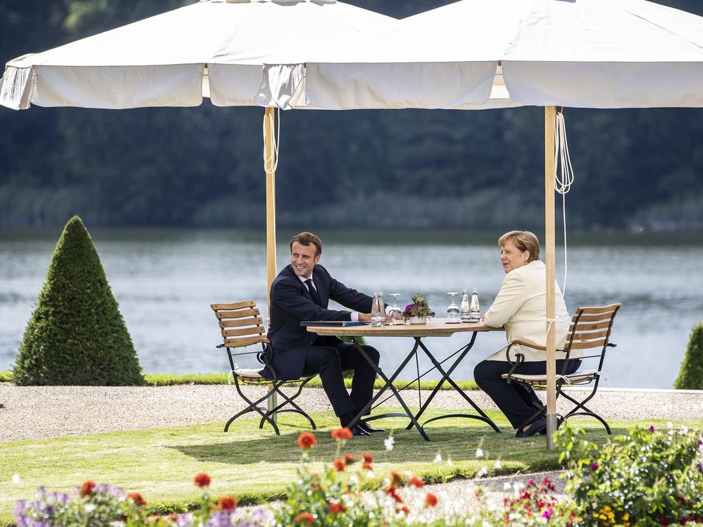 German Chancellor Angela Merkel and French President Emmanuel Macron hold a socially distant chat as they prepare to bar travellers from certain countries from the EU. Picture: Maja Hitij/Pool/Getty Images