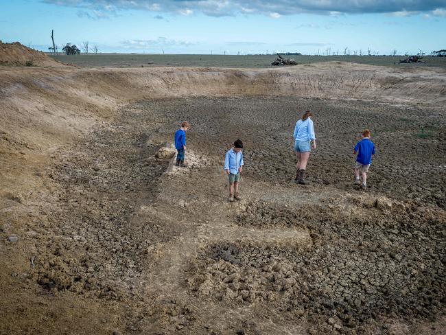 The Anderson family inside one of their property’s dried-out dams. Picture: Jake Nowakowski