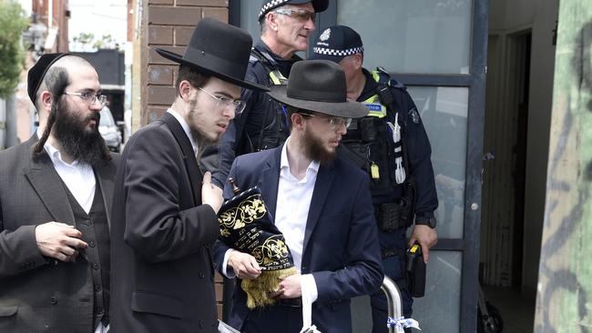 Synagogue members remove religious material from Adass Israel synagogue at Ripponlea after an overnight fire. Picture: NewsWire /Andrew Henshaw