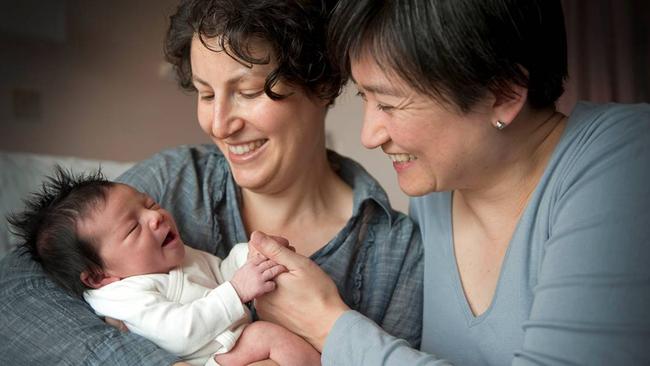 Senator Penny Wong, right, with her partner Sophie Allouache in 2011, and their baby Alexandria.