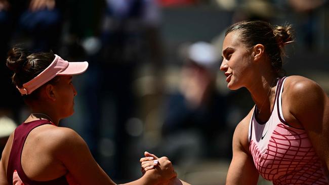 Sabalenka (right) shakes hands with Russia's Kamilla Rakhimova. (Photo by JULIEN DE ROSA / AFP)