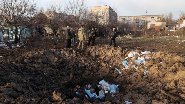 Ukrainian servicemen inspect a crater near a house which was destroyed by Russian forces in the village of Bachtanka near Mykolaiv, a key city on the road to Odessa on March 27, 2022. Picture: Oleksandr Gimanov/AFP