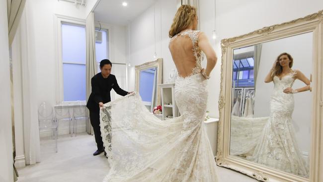 Eternal Bridal's Sebastian Lee helps a client with their dress in his Armadale store. Picture: Supplied.