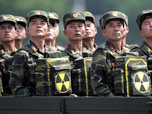 North Korean soldiers turn and look towards their leader Kim Jong Un from a military parade vehicle as they carry packs marked with the nuclear symbol during a ceremony marking the 60th anniversary of the Korean War armistice in Pyongyang, North Korea. Picture: AP / Wong Maye-E