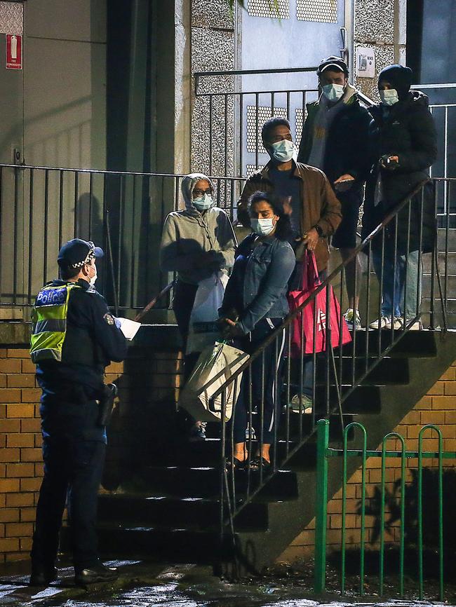 Police question residents of a locked-down housing estate. Picture : Ian Currie