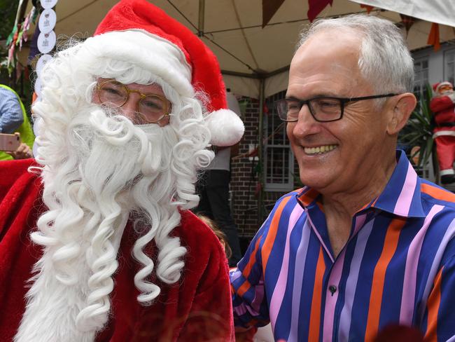 Australian Prime Minister Malcolm Turnbull meets Santa during the annual Wayside Chapel Christmas lunch and street party in Kings Cross, Sydney, Monday, December 25, 2017. The Wayside Chapel Christmas lunch is a free event to give homeless and anyone else that wishes to come along for a Christmas lunch and and celebrate the joy of Christmas. (AAP Image/Dean Lewins) NO ARCHIVING