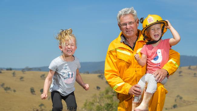 Rod O'Connell, 64 with grandkids Holly Mitchell, 5, and Chloe, 3. The girls have returned home to Omeo after evacuating amid the fire threat. Picture: Jason Edwards