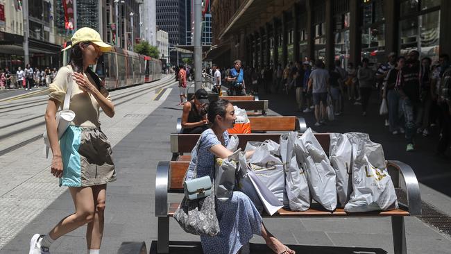 A woman takes a break from shopping in the Sydney CBD during Boxing Day. Picture: Getty