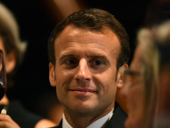 France's President Emmanuel Macron raises  glass in a toast during a dinner in his honour at the Sydney Opera House in Sydney on May 1, 2018.  Macron arrived in Australia on May 1 on a rare visit by a French president with the two sides expected to agree on greater cooperation in the Pacific to counter a rising China. / AFP PHOTO / POOL / MICK TSIKAS