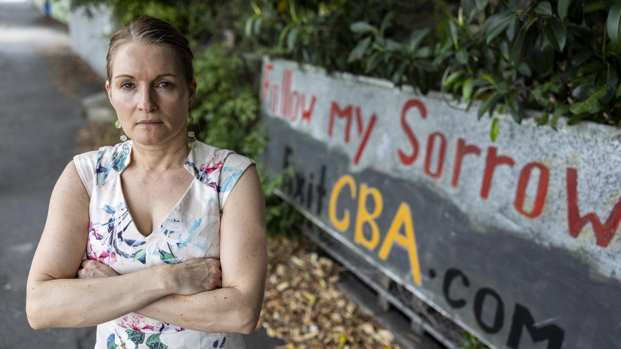 Dr Loretta McKinnon at her Windsor rental which she tried to buy and claims is rightfully hers. She has erected signs slamming her bank, the Commonwealth Bank of Australia (CBA). Picture: Matthew Poon