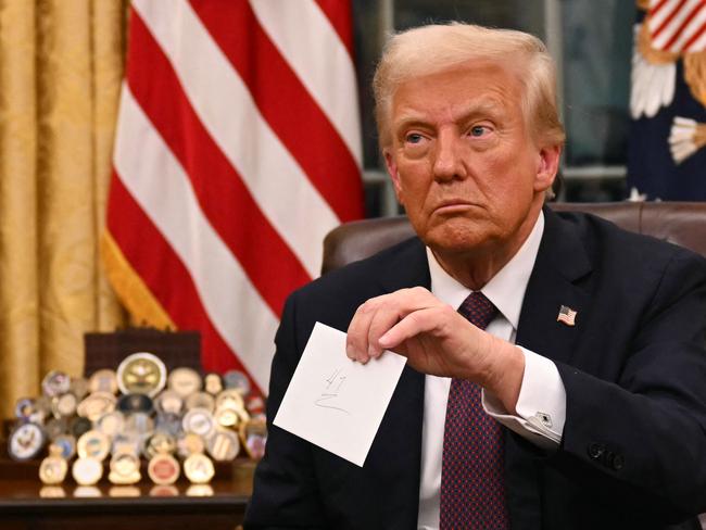 Donald Trump holds up outgoing President Joe Biden's letter. Picture: AFP