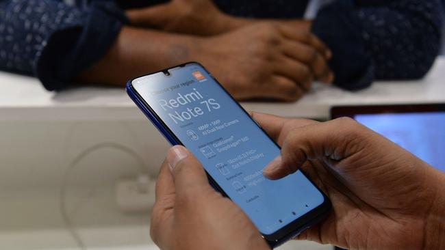 A salesman shows features to a customer after he bought a smartphone made by Xiaomi. Picture: AFP