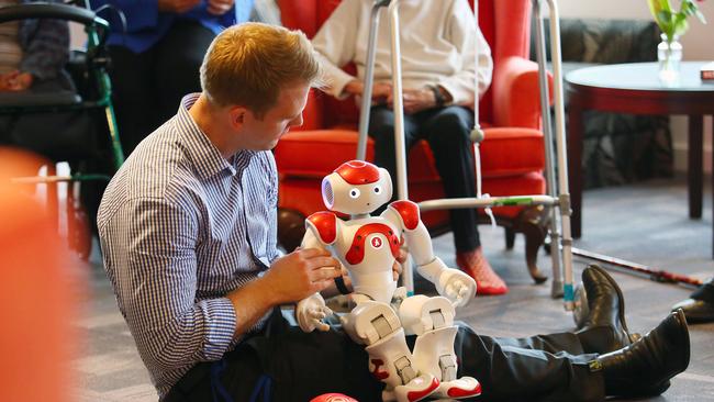 MMV head of rehabilitation Murray Johnson has programmed the robots to do tai chi, play soccer and sing songs.