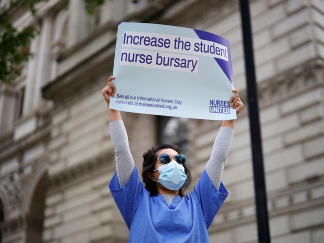 A nurse who works at central London hospitals protests with a placard outside Downing Street. Picture: AFP