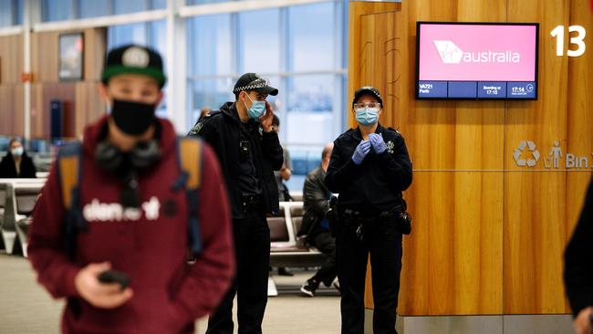 Police and passengers wearing masks at Adelaide Airport after SA announced a border closure to NT, WA, QLD and the ACT on Sunday. Picture: Morgan Sette