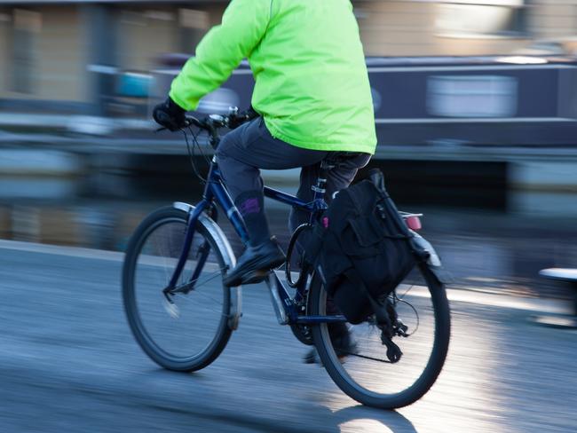 A person cycling down a cannal walkway