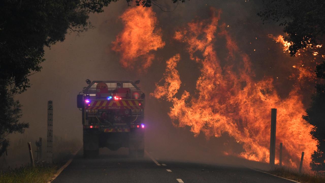 A fire truck is almost hit by flames at Nana Glen, near Coffs Harbour. Picture: AAP